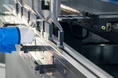 Hidrolik fren bükme makinesiyle çalışan teknisyen. Yetenek operatörünün kullandığı levha metal çalışması.