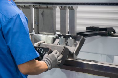 Hidrolik fren bükme makinesiyle çalışan teknisyen. Yetenek operatörünün kullandığı levha metal çalışması.