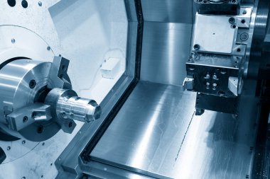 CNC torna makinesi metal parçalarını kesiyor. CNC dönüşüm makinesinin yüksek teknolojili metal işlemesi .