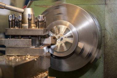 Torna makinesi torna malzemeleriyle metal parçaları kesiyor. Makineyi döndürerek metal işleme süreci.