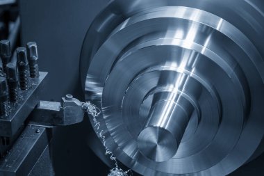 Torna makinesi pirinç şaft parçalarını torna araçlarıyla kesiyor. Makineyi döndürerek metal işleme süreci.