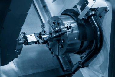 CNC torna makinesinin metal parçalarını tutan otomatik robot kolu. Dönüşüm makinesinde robotik sistem tarafından yüksek teknoloji materyal işleme süreci. 