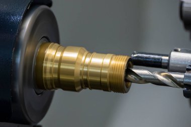 CNC torna makinesi, pirinç boru bağlantı parçalarını kesiyor. CNC dönüşüm makinesinin yüksek teknolojili metal işlemesi .