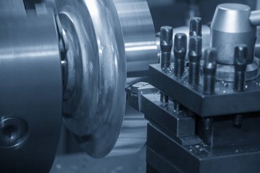 Torna makinesi pirinç şaft parçalarını torna araçlarıyla kesiyor. Makineyi döndürerek metal işleme süreci.