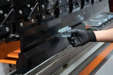 Hidrolik fren bükme makinesiyle çalışan teknisyen operatörün eli. Yetenek operatörünün kullandığı levha metal çalışması.
