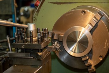 Torna makinesi torna malzemeleriyle metal parçaları kesiyor. Makineyi döndürerek metal işleme süreci.