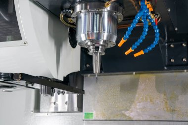5 eksenli makine merkezinin yakın çekim sahnesi. Çok eksenli CNC değirmen makinesinin yüksek hassasiyetli otomotiv üretim süreci.