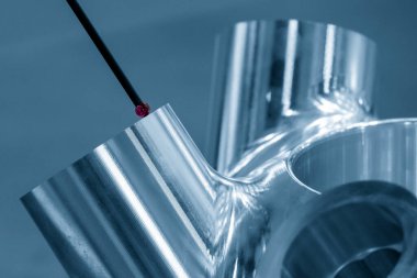 Alüminyum parçayı ölçen çok eksenli CMM sondasının yakın çekim sahnesi. CMM makinesiyle otomotiv parçalarının kalite kontrolü.