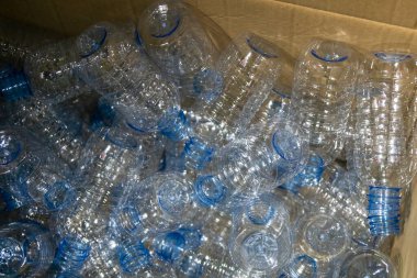 İçme suyu fabrikasındaki işlemleri tamamlamak için konteyner kutusundaki boş PET şişeleri. Plastik şişe üretim sürecinin yüksek teknolojisi..