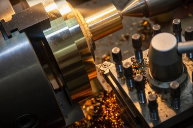 Torna makinesi pirinç şaft parçalarını torna araçlarıyla kesiyor. Makineyi döndürerek metal işleme süreci.