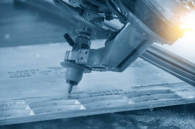 NC kod veri arka planına sahip çok eksenli su jeti kesme makinesi. CNC makinesiyle çalışan yüksek teknoloji levha metali.