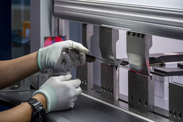 Техник-оператор, работающий с гидравлическим станком управления лазерным лучом. Работа с листовым металлом оператором мастерства.