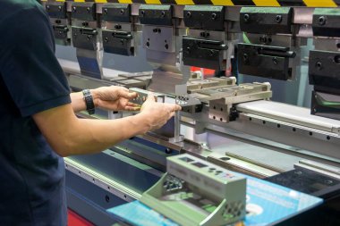 Hidrolik fren bükme makinesiyle çalışan teknisyen operatörün eli. Yetenek operatörünün kullandığı levha metal çalışması.