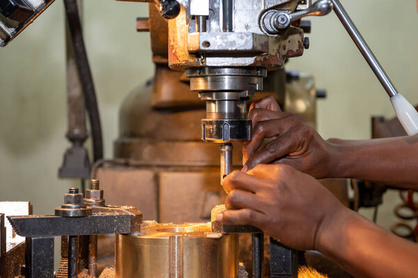 The machine operator working with NC milling machine. The shop floor operation by NC milling machine.