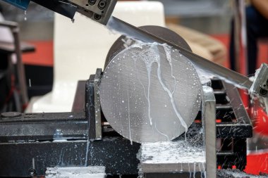 Otomatik bant testeresi metal çubuğu su bazlı soğutucu metoduyla kesiyor. Endüstriyel amaç için makine aracı.