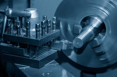 Torna makinesi pirinç şaft parçalarını torna araçlarıyla kesiyor. Makineyi döndürerek metal işleme süreci.