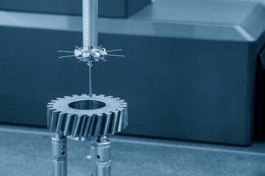 Yakın çekim sahnesi, tetik dişli kısmını ölçen CMM makinesinin dokunmatik sondası. CMM makinesiyle otomotiv parçalarının kalite kontrolü.
