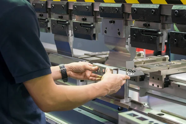 Hidrolik fren bükme makinesiyle çalışan operatör. Yetenek operatörünün kullandığı levha metal çalışması.