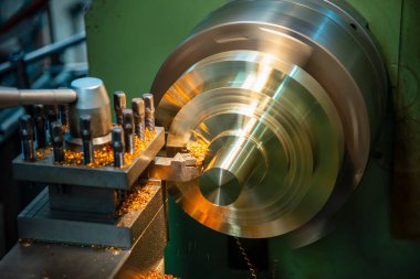 Torna makinesi pirinç disk parçalarını torna ile kesmeyi bitirir. Makineyi döndürerek metal işleme süreci.