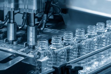 İçme suyu fabrikasındaki PET şişelerinin işlendiği soyut sahne. Plastik şişe üretim sürecinin yüksek teknolojisi..