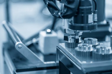 Metal parçalı robotik sistem tarafından yapılan yüksek teknoloji malzeme işleme süreci. Otomatik pnömatik robotik kol üretim hattındaki mekanik parçaları seçer. 