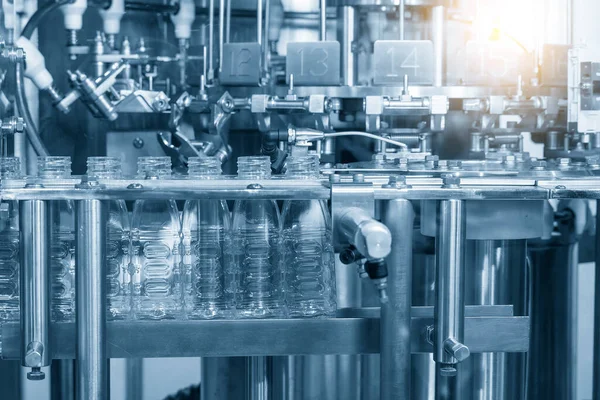 The empty water bottles  on the conveyor belt for filling process in the filling machine. The hi-technology of drinking water   manufacturing process.