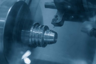CNC torna makinesi metal koni şeklindeki parçaları kesiyor. CNC dönüşüm makinesinin yüksek teknolojili metal işlemesi .