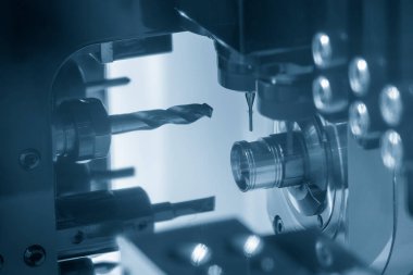 Çoklu görev yapan CNC torna makinesi İsviçre tipi metal parçaları deliyor. CNC dönüşüm makinesiyle çalışan yüksek teknoloji metali.