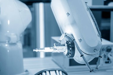 CNC torna makinesinin metal parçalarını tutan otomatik robot kolu. Dönüşüm makinesinde robotik sistem tarafından yüksek teknoloji materyal işleme süreci. 