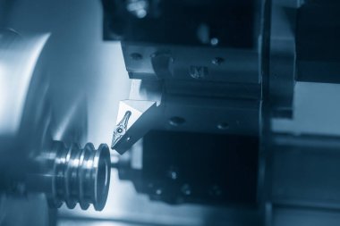 CNC torna makinesi oluğu metal makara kısmını kesiyor. CNC dönüşüm makinesinin yüksek teknolojili metal işlemesi .