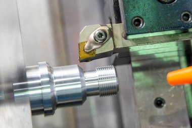 CNC torna makinesi metal çivi parçalarının sonunda iplik kesiyor. CNC dönüşüm makinesinin yüksek teknolojili metal işlemesi .