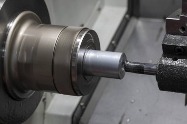 Torna makinesi, torna tezgahlarıyla metal parçalarını kesmeye başladı. Makineyi döndürerek metal işleme süreci.