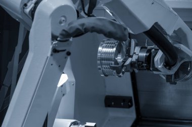 CNC torna makinesinin metal parçalarını tutan otomatik robot kolu. Dönüşüm makinesinde robotik sistem tarafından yüksek teknoloji materyal işleme süreci. 
