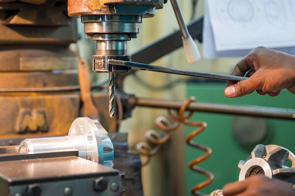The machine operator use wrench tighten  the spindle for change drill tool. The drilling process on NC milling machine.