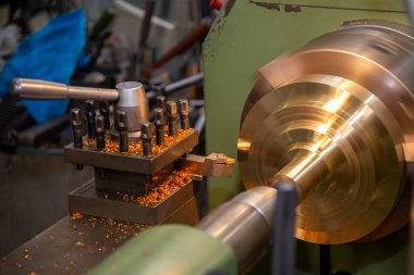Torna makinesi, metal disk parçalarını torna tezgahlarına göre kesiyor. Makineyi döndürerek metal işleme süreci.