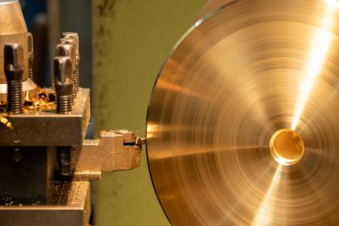 The lathe machine finish cut the metal disk parts by lathe tools. The metalworking process by turning machine.
