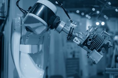 The automatic  robotic arm gripping the motorbike engine parts. The hi-technology  material handling process by robotic system in automotive assembly factory. 