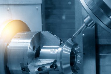 The multi-tasking CNC machine  cutting the differential gear part. The hi-technology automotive part manufacturing process by CNC lathe.