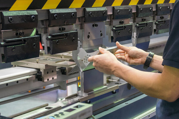 The skill operator working with hydraulic press brake bending machine. The sheet metal working operation by skill operator.