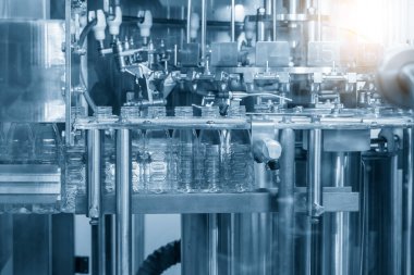 The empty water bottles on the conveyor belt for filling process in the drinking water factory. The hi-technology of drinking water   manufacturing process.