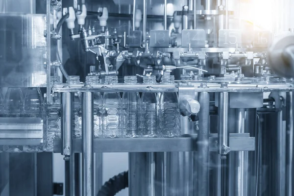 The empty water bottles on the conveyor belt for filling process in the drinking water factory. The hi-technology of drinking water   manufacturing process.