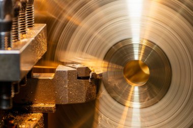 Closeup scene the lathe machine finish cut the brass parts by lathe tools. The metalworking process by turning machine.