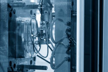 The automatic operation of plastic injection machine with robotic system. The plastic container production manufacturing process by injection machine.