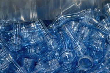 PET şişe ürünlerinin önceden biçimlendirilmiş hali yakın çekim sahnesi. Plastik şişe üretim süreci için hammadde.