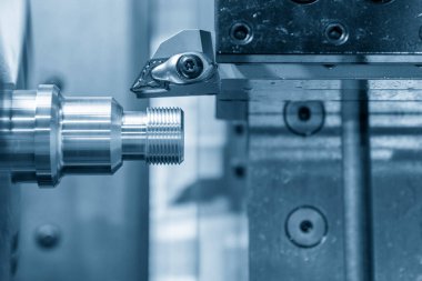 CNC torna makinesi metal çivi parçalarının sonunda iplik kesiyor. CNC dönüşüm makinesinin yüksek teknolojili metal işlemesi .