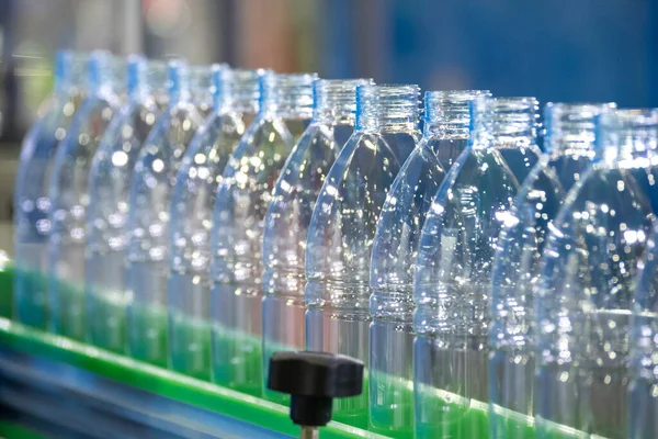 The empty drinking water bottles  on the conveyor belt for filling process. The hi-technology of drinking water manufacturing process.