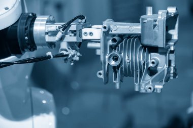 The automatic  robotic arm gripping the motorbike engine parts. The hi-technology  material handling process by robotic system in automotive assembly factory. 