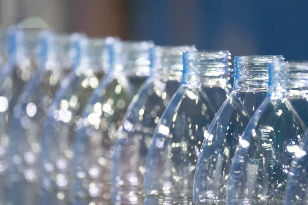 Close up scene of the empty drinking water bottles  on the conveyor belt for filling process. The hi-technology of drinking water manufacturing process.