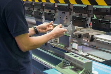 Hidrolik fren bükme makinesiyle çalışan beceri operatörü. Yetenek operatörünün kullandığı levha metal çalışması.