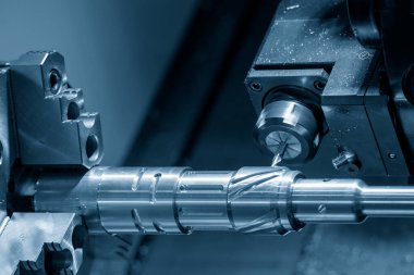 The multi-tasking CNC lathe machine  groove cutting the brass shaft parts by milling spindle. The high technology metal working with CNC turning machine.
